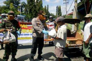 Kapolres Grobogan AKBP Ronny Tri Prasetyo Nugroho didampingi Dandim 0717 Purwoadadi, Letkol (Inf) Asman Mokoginta menyerahkan sembako kepada tukang becak, Kamis (9/4/2020). (Semarangpos.com/Arif Fajar S.)