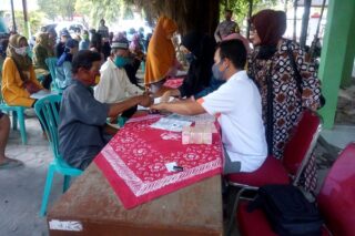 Petugas Kantor Pos Purwodadi meminta penerima bantuan sosial tunai (BST) dari Kelurahan Kalongan,  membubuhkan cap jempol, Sabtu (18/7/2020). (Semarangpos.com-Arif Fajar Setiadi)