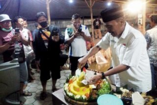 Lurah Purwodadi Hendro Sutopo memotong tumpeng bersama pemancing saat malam tirakatan, Minggu (16/8/2020) malam. (Semarangpos.com-Arif Fajar Setiadi)